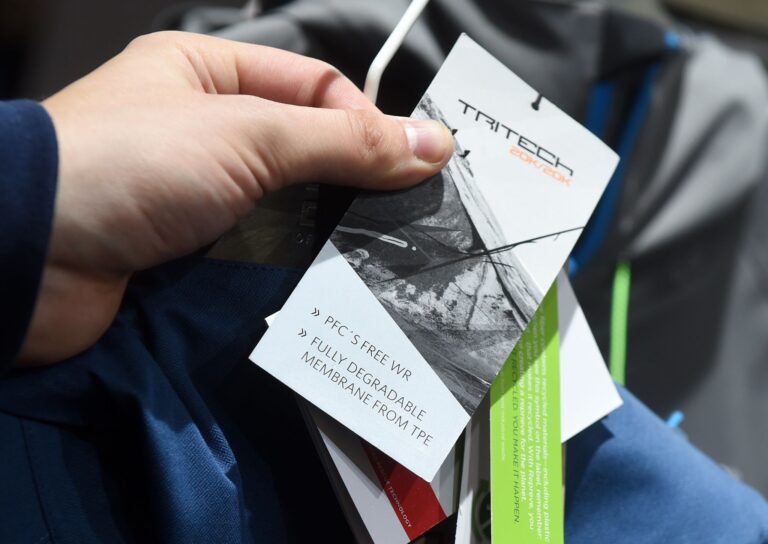 Ein Mann hält ein PFC-frei-Etikett an einer Sportkleidung